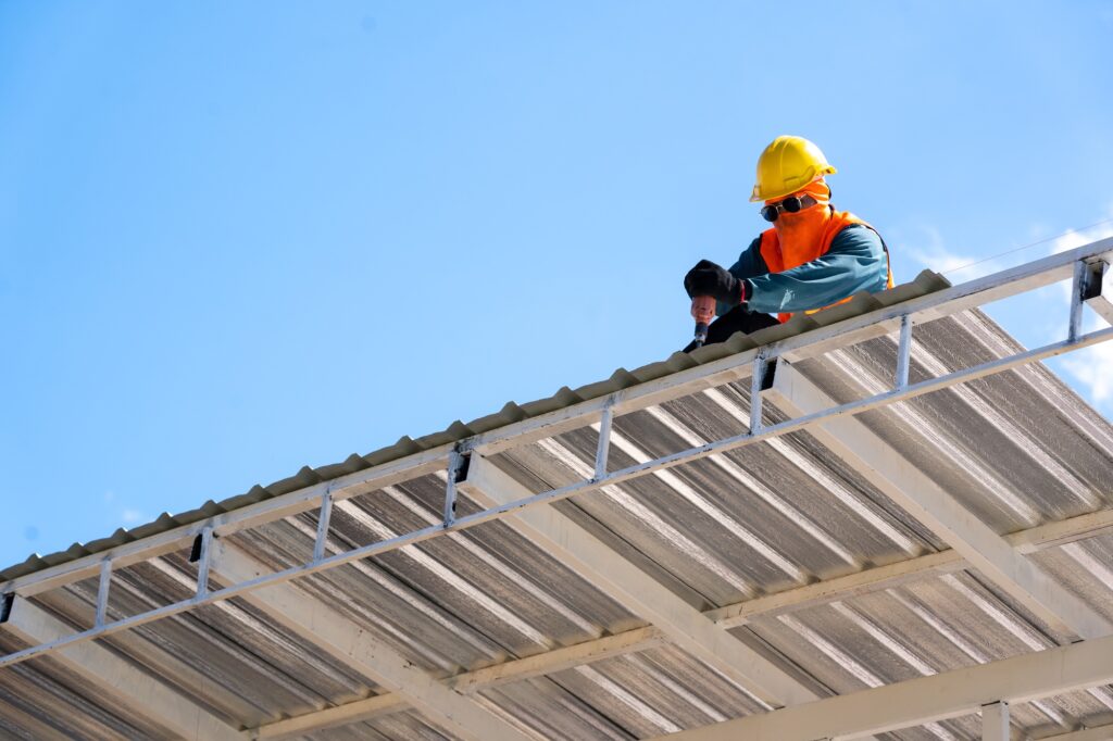 Roofing,Construction workers wearing safety harness checking and installation assembly of new roof.